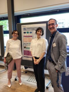 Monika Stärk, Henriette Müller-Ahrndt, and Christian Schmit-Engel in front of the iRTG poster supporting the EBM team. Photo: A. Dakkouri-Baldauf